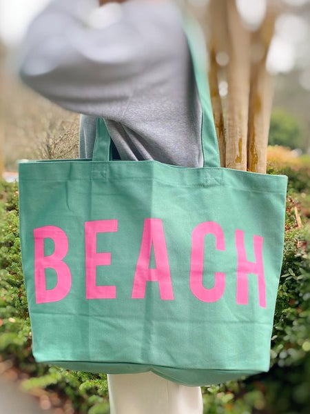 Babe Beachwear Canvas Beach Tote in mint green with pink BEACH lettering carried on shoulder