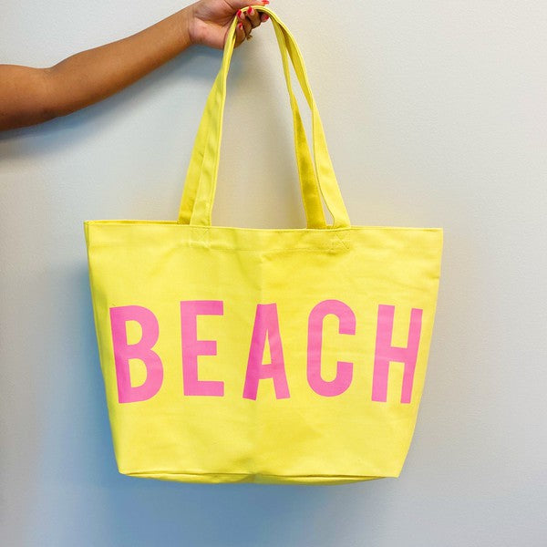 Yellow canvas beach tote with pink BEACH lettering and long handles by Babe Beachwear