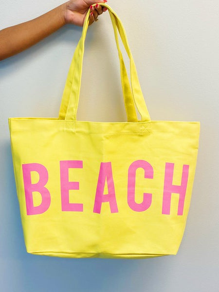 Yellow canvas beach tote with pink BEACH lettering and long handles by Babe Beachwear