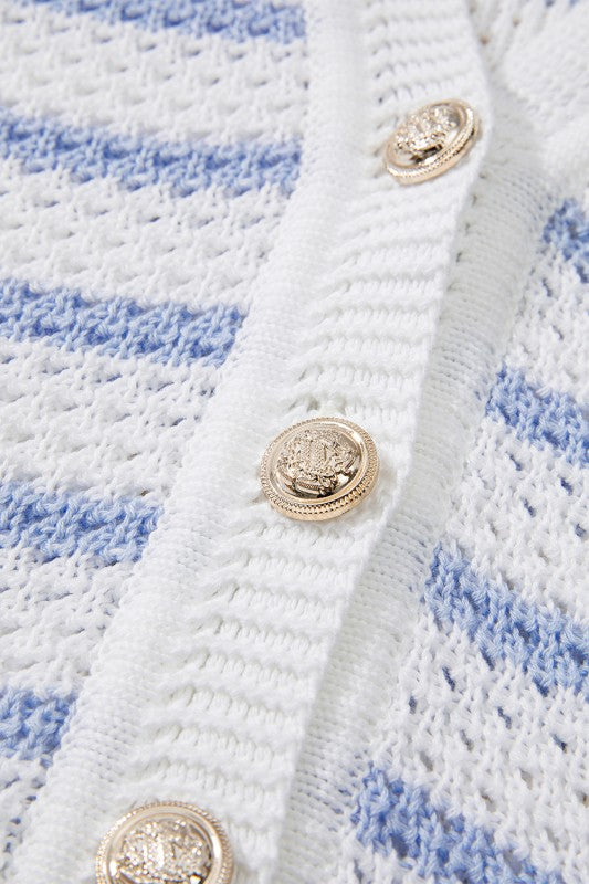 Close-up of EG fashion casual beachwear knit top with gold decorative buttons on white and blue sleeveless shirt