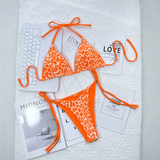 Beach Babes orange leopard print cheeky bottom triangle swimsuit with adjustable ties laid on white surface