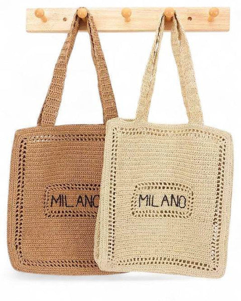 Chic Milano Straw Tote Bag – Your Essential Beach Wear in natural and brown colors hanging on wooden hooks