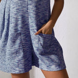 Close-up of chic summer leisurewear romper in blue textured fabric with front pocket detail