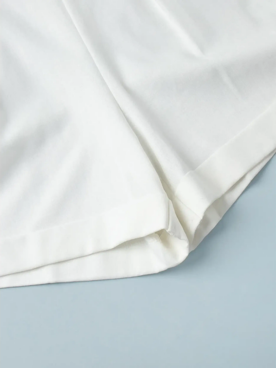 Close-up of white fabric hem detail of a Classy Long Sleeve Romper by Trendsi