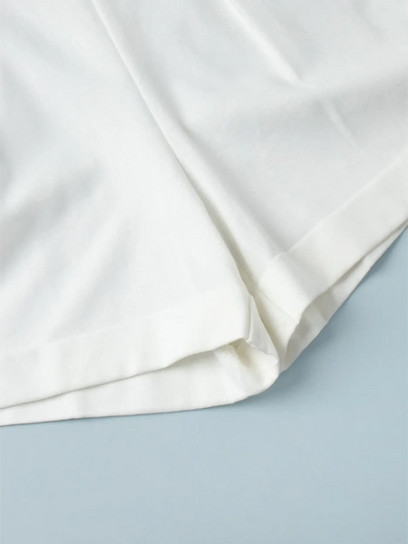 Close-up of white fabric hem detail of a Classy Long Sleeve Romper by Trendsi