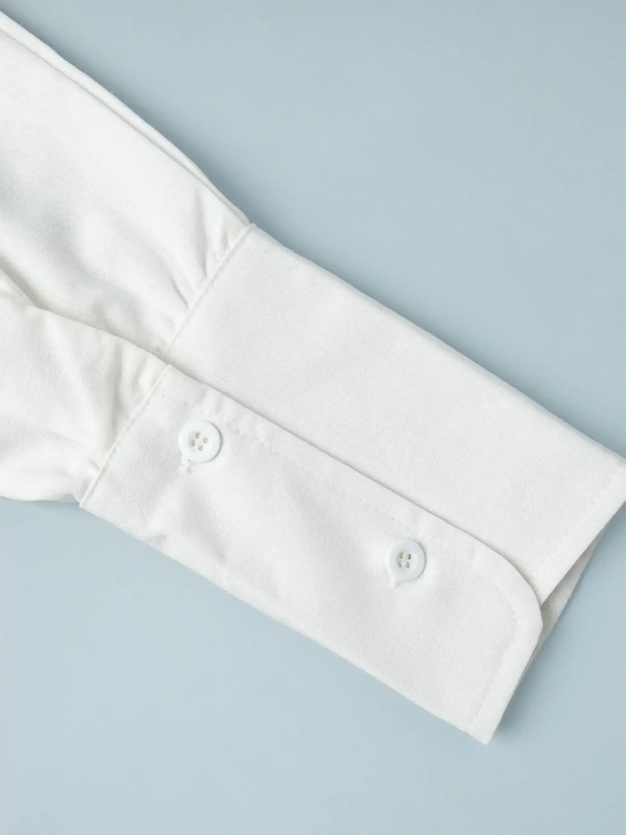 Close-up of white cuff with buttons on Classy Long Sleeve Romper by Trendsi
