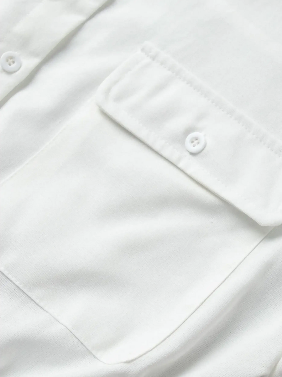 Close-up of white fabric pocket with button detail on a Classy Long Sleeve Romper by Trendsi