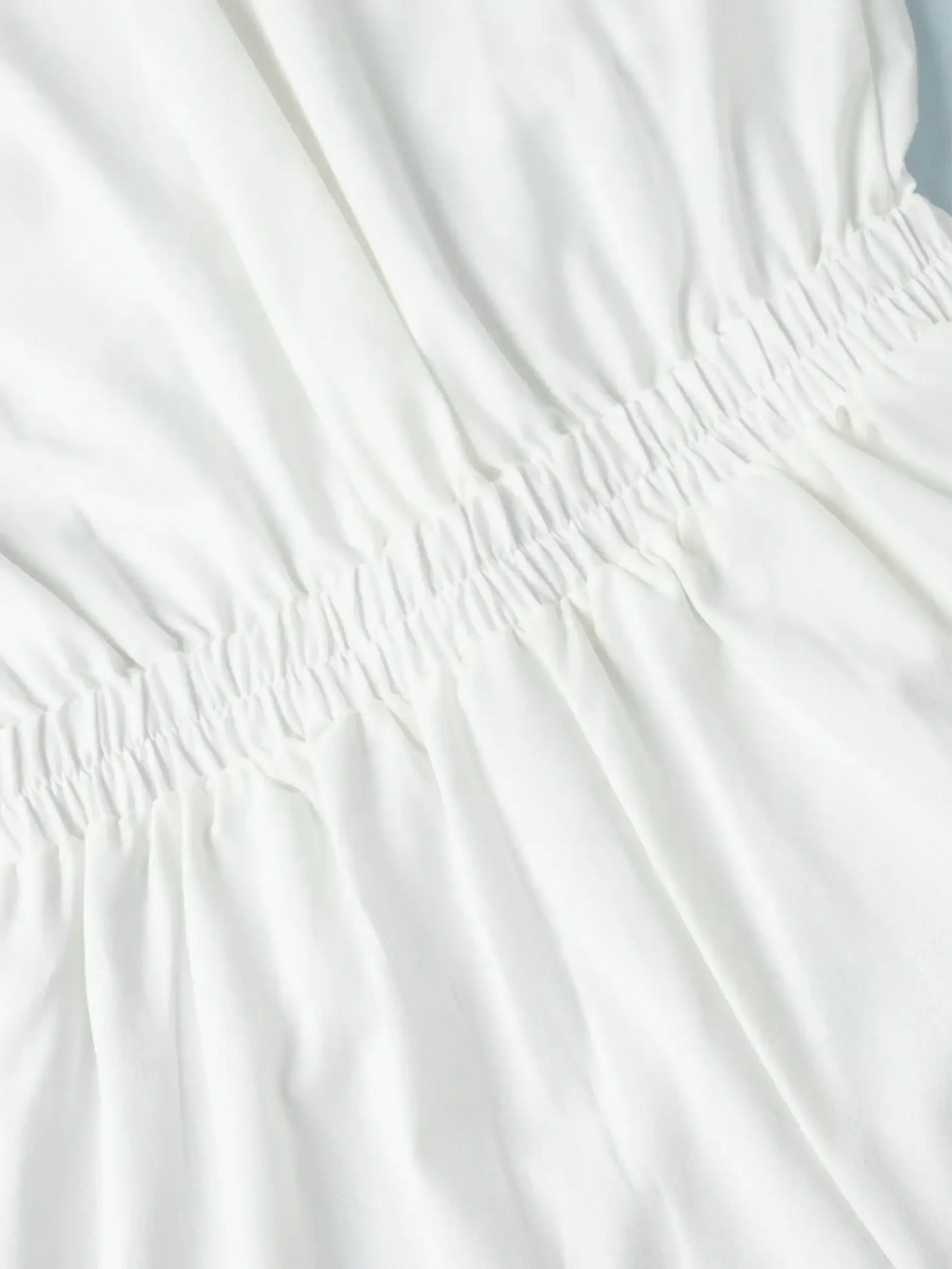 Close-up of white fabric with gathered elastic detail on a Classy Long Sleeve Romper from Trendsi