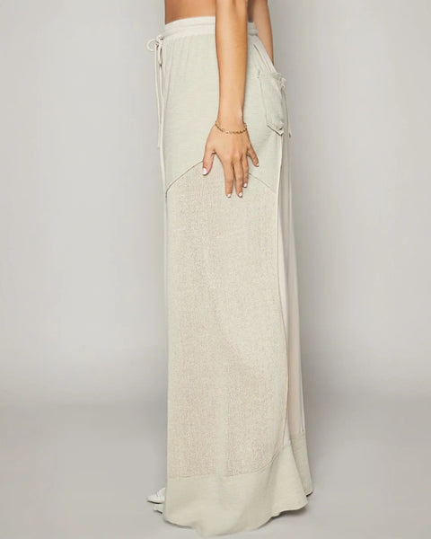 Long light-colored skirt styled with chic cotton cream wide leg pants for summer vibes