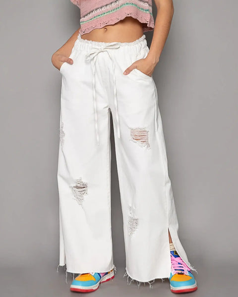 Ripped white cotton beach pants for a fashion forward summer look in wide leg beach pants