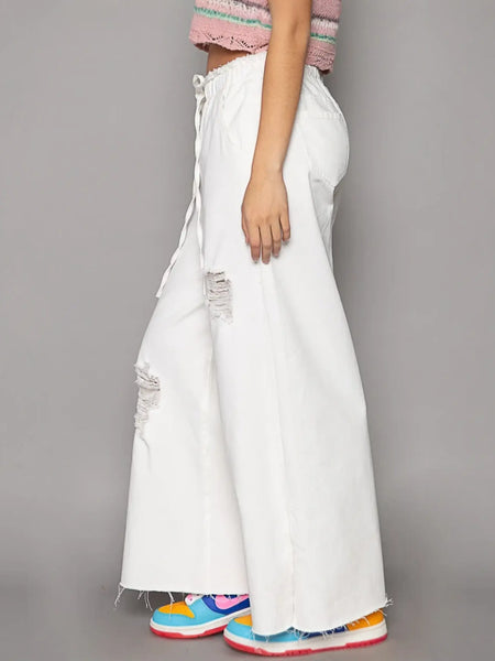 White distressed cotton beach pants for a fashion forward summer look