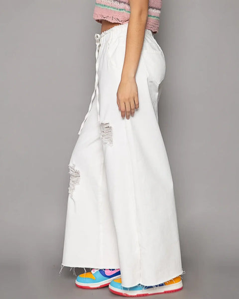 White distressed cotton beach pants for a fashion forward summer look