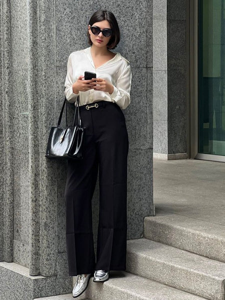 Woman wearing Babe Beachwear comfortable slip-on loafers for travel paired with black pants and white blouse