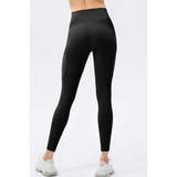 Trendsi black compression slim fit workout pants for women shown from the back with white sneakers