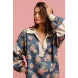 Woman wearing a Babe Beachwear contrast collar summer romper with floral print and long puff sleeves