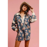 Woman wearing a Babe Beachwear contrast collar summer romper with floral print and long sleeves worn with a hat