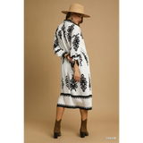 Trendsi long sleeve resort tunic dress in cream with black patterns worn with tan hat and brown ankle boots
