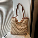 crochet tote bag with leather handles in beige with brown trim shown hanging against a window