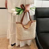 crochet tote bag with leather handles held by person wearing white dress and holding white tulips