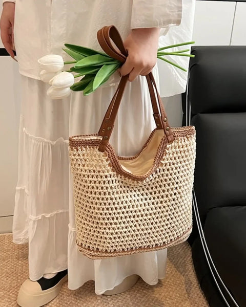 crochet tote bag with leather handles held by person wearing white dress and holding white tulips