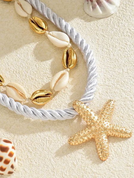 Trendsi cruise wear beaded rope necklace with gold starfish pendant and shell details on sandy background