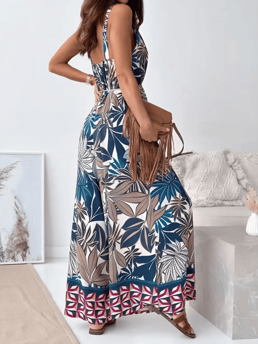Trendsi Earth Toned Tropical Jumpsuit with sleeveless design and wide-leg pants worn with brown fringe bag