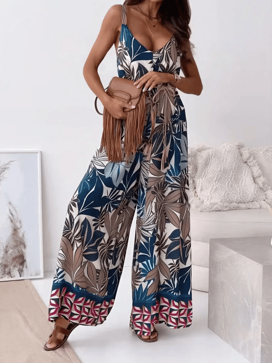 Trendsi Earth Toned Tropical Jumpsuit with wide legs and tropical leaf print worn with brown fringe bag