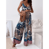 Trendsi Earth Toned Tropical Jumpsuit with wide legs and tropical leaf print worn with brown fringe bag