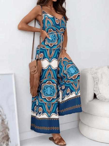 Woman wearing an Earth Toned Tropical Jumpsuit with blue and brown geometric patterns from Trendsi