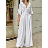 Elegant wide-leg beachwear jumpsuit by Babe Beachwaer in white with a deep V-neck and flowing sleeves
