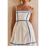 woman showing white contrast trim midi dress with blue piping and spaghetti straps