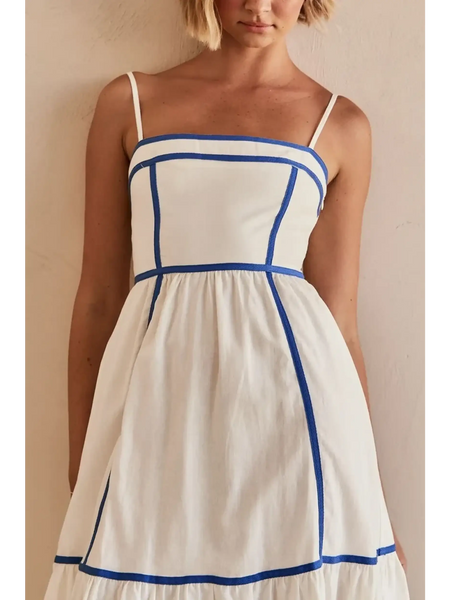 woman showing white contrast trim midi dress with blue piping and spaghetti straps