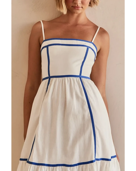 woman showing white contrast trim midi dress with blue piping and spaghetti straps