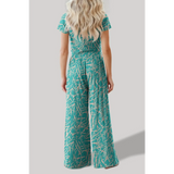 Back view of woman wearing turquoise crop top pants set with abstract print from Trendsi