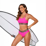Trendsi fierce pink bikini for beach with leopard print trim worn by woman holding surfboard