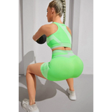 Babe Beachwaer neon green color block sports bra and shorts set worn by woman exercising