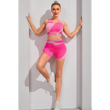 Babe Beachwaer pink color block sports bra and shorts set worn by woman posing against white wall