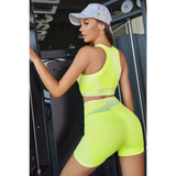 Babe Beachwear neon yellow color block sports bra and shorts set worn by woman in gym