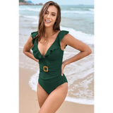 Babe Beachwear flattering one piece swimwear in dark green with ruffle straps and a belt on a smiling model at the beach