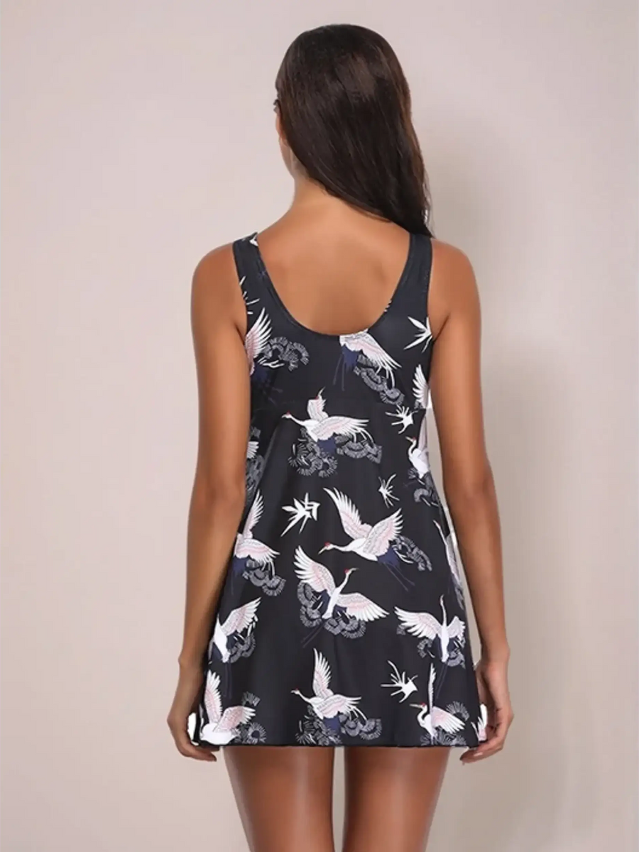 Beach Babes full coverage skirt swimsuit with white bird print on black fabric shown from back