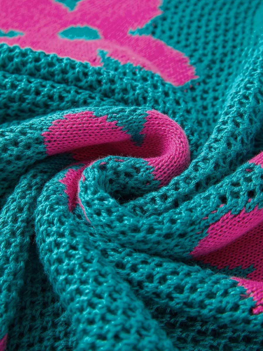 Close-up of teal crochet top with pink floral pattern showing floral mesh beach sweater texture