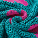 Close-up of teal crochet top with pink floral pattern showing floral mesh beach sweater texture
