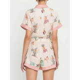 Back view of floral resort romper for women by Trendsi with short sleeves and pink trim