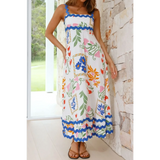 woman wearing floral resort wear dress with colorful floral patterns and blue trim maxi dress