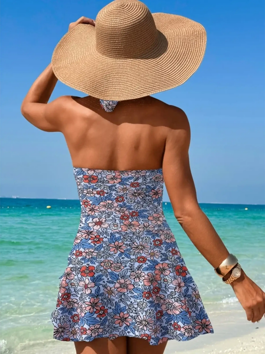 Beach Babes sexy cutout swim dress with floral pattern worn at the beach by woman with sunhat