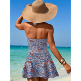Beach Babes sexy cutout swim dress with floral pattern worn at the beach by woman with sunhat