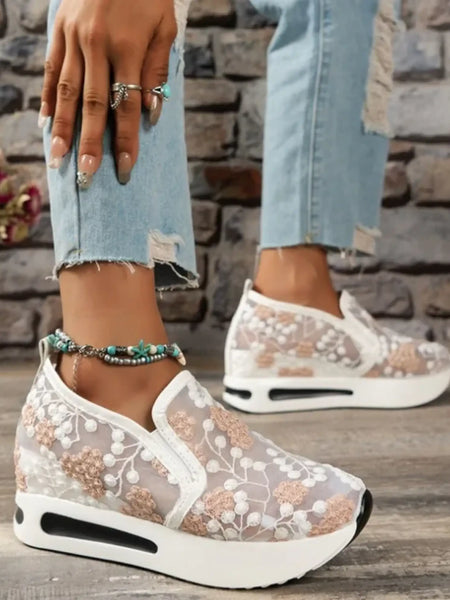 Trendsi slip on platform sneakers with white floral lace design and thick sole worn with ripped jeans