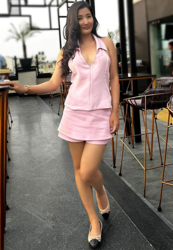 Woman wearing Rag Company nude and silver ballet flats with a pink sleeveless top and skirt