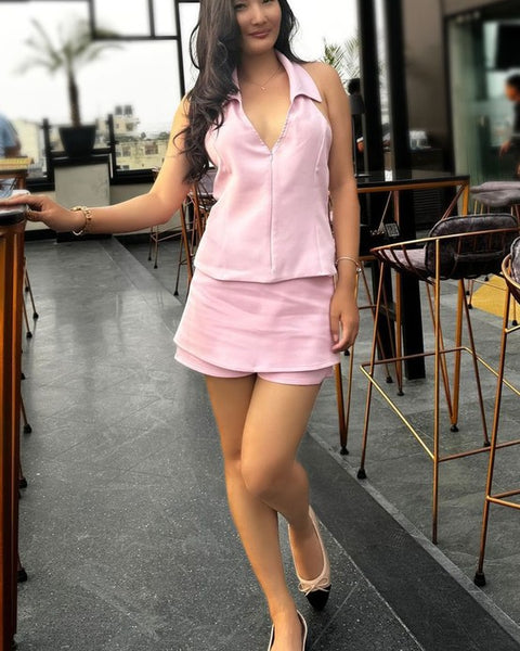 Woman wearing Rag Company nude and silver ballet flats with a pink sleeveless top and skirt