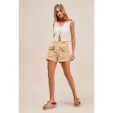 Trendsi beige high rise cargo shorts with large front pockets worn by model with white sleeveless top